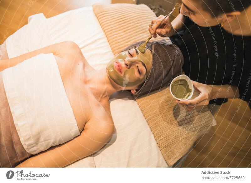 Entspannende Gesichtsbehandlung in einem Spa mit Tonerdemaske Behandlung Mundschutz Kosmetikerin Erholung Hautpflege Schönheit Gesundheit Wellness Pflege