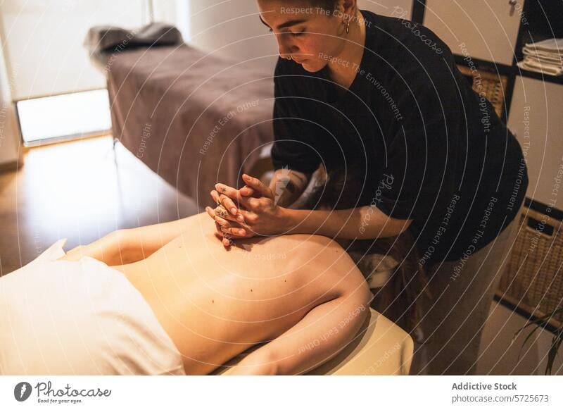 Therapeut gibt entspannende Schultermassage im Spa Massage Klient Erholung Windstille Therapie professionell Wohlbefinden Behandlung berühren Heilung Komfort