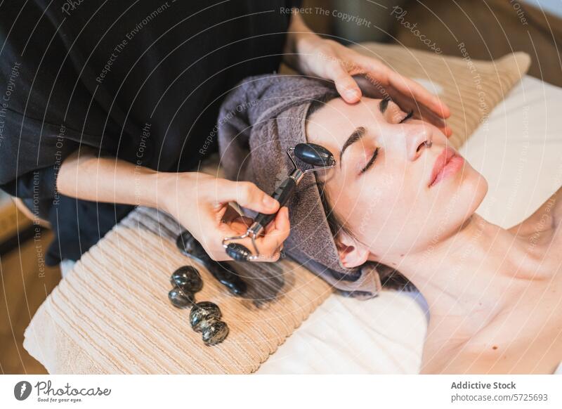 Entspannende Gesichtsmassage in einem Wellness-Spa mit Jadewalze Frau Gesichtsbehandlung Massage Jade-Walze Hautpflege Erholung ruhig Behandlung Schönheit