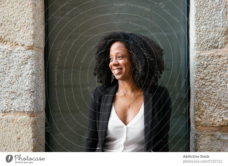 Selbstbewusste schwarze Geschäftsfrau lächelnd in der Nähe des Bürogebäudes Frau Afroamerikaner professionell Lächeln selbstbewusst krause Haare