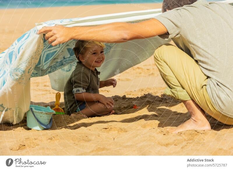 Fröhliche Strandmomente mit der Familie Kleinkind Spaß Sand spielen Lächeln Fröhlichkeit Zelt Sommer Freude Zusammengehörigkeitsgefühl Freizeit Urlaub Küste