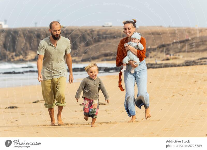 Familienglück bei einem Spaziergang am Sandstrand Strand Spaß MEER Klippen Küstenlinie Kleinkind Baby Eltern Lächeln Freude im Freien Freizeit Aktivität lässig