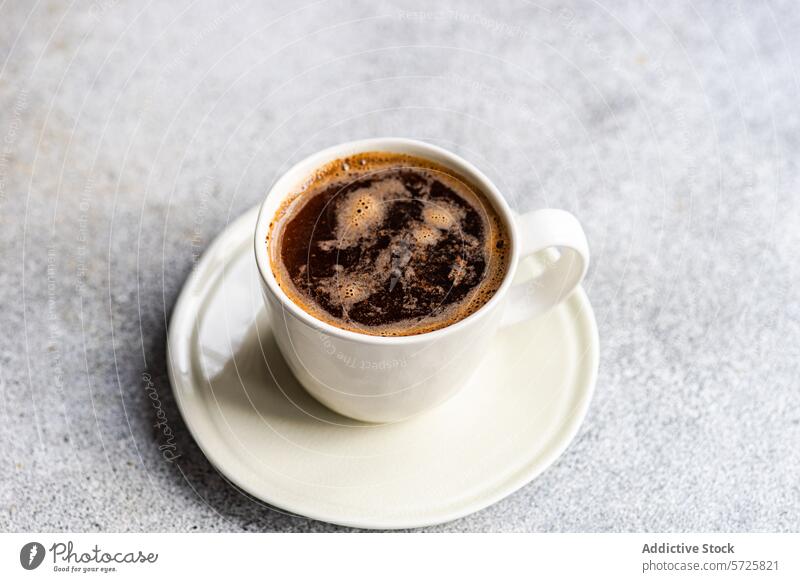 Frisch gebrühter Morgenkaffee in weißer Tasse auf Untertasse Kaffee brauen Keramik schwarzer Kaffee Blasen trinken Getränk Koffein frisch Tischplatte
