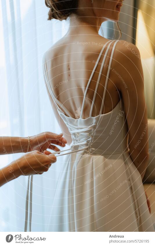 Vorbereitungen für die Braut mit dem Anziehen des Hochzeitskleides Schönheit Brautjungfernkleid Kleid Dressing Mode befestigen Gebühren Freundinnen