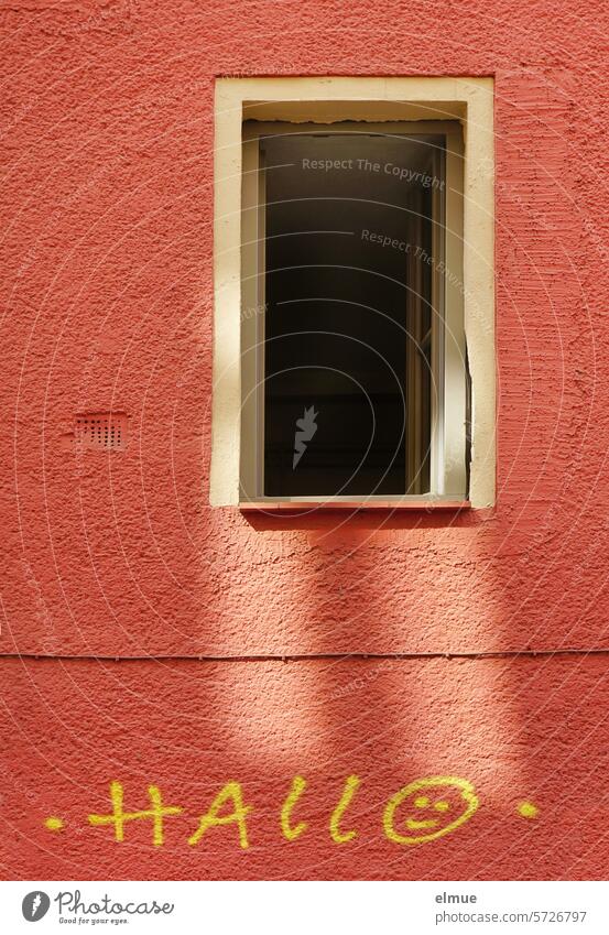 HALLO mit Smiley steht an einer roten Hauswand unter einem offenen Fenster Hallo Smiley-Gesicht Begrüßung Fassade Graffiti Schmiererei rote Wand Straßenkunst