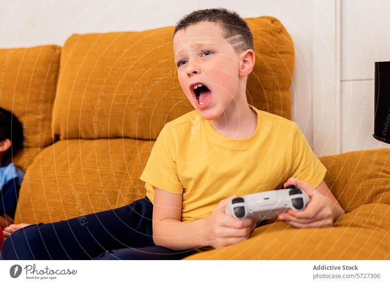 Frustrierter Junge, der zu Hause ein Videospiel verliert Frustration Emotion Liege Wohnzimmer Regler Spieler Spielen Reaktionen u. Effekte expressiv