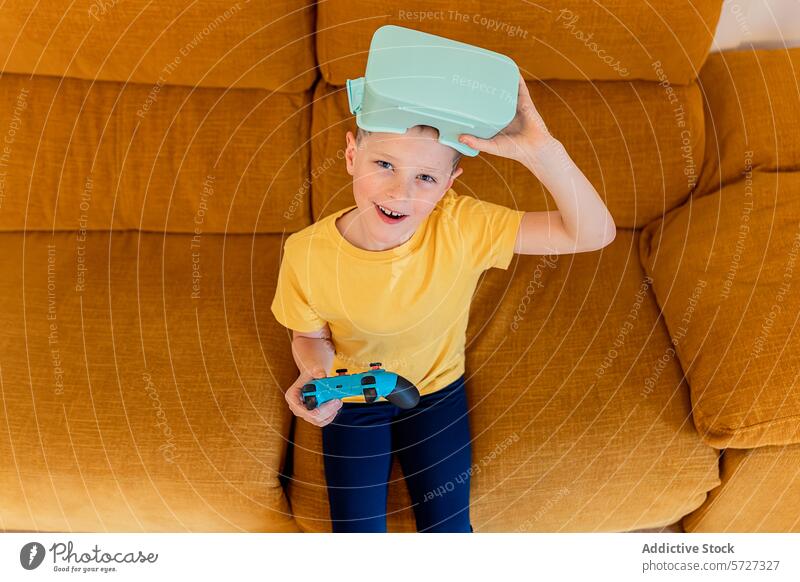 Junger Gamer mit VR-Headset und Controller auf der Couch Virtuelle Realität vr-kopfhörer Regler Spielen Liege Senf spielerisch Ausdruck Sitzen