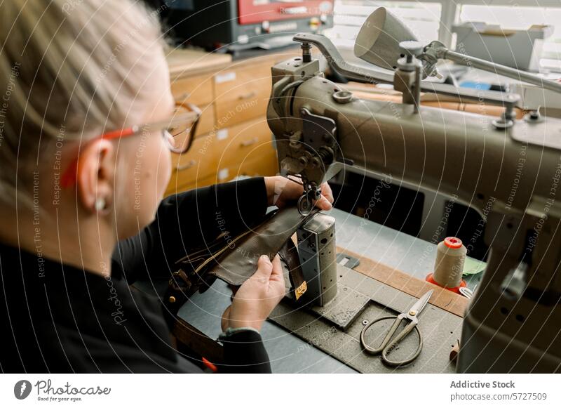 Kunsthandwerklicher Schuhmacher bei der Arbeit in einer österreichischen Werkstatt Kunstgewerbler Schuster Österreich Handwerkskunst Leder Nähmaschine Näherei