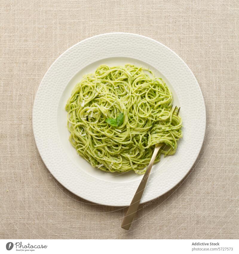 Teller Spaghetti mit Pestosauce auf einem Leinentischtuch Spätzle Italienisch Saucen Tischwäsche Lebensmittel Speise Mahlzeit Basilikum grün weiß beige Küche