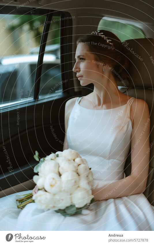 Braut mit schwarzem Auto in der Nähe eines gläsernen Wolkenkratzers PKW nah Glas Hotel Straße weiß grau Asphalt blau Gebäude Hochzeit Blumenstrauß stehen