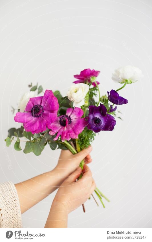 Hände einer Frau, die einen Blumenstrauß auf weißem Hintergrund hält. Ich kann mir Blumen kaufen. Alles Gute zum Geburtstag oder Jahrestag. geblümt