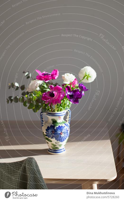 Vase mit einem Strauß rosa und lila Blumen in einer Keramikvase auf dem Tisch. Ich kann mir selbst Blumen kaufen. Alles Gute zum Geburtstag oder Jahrestag.