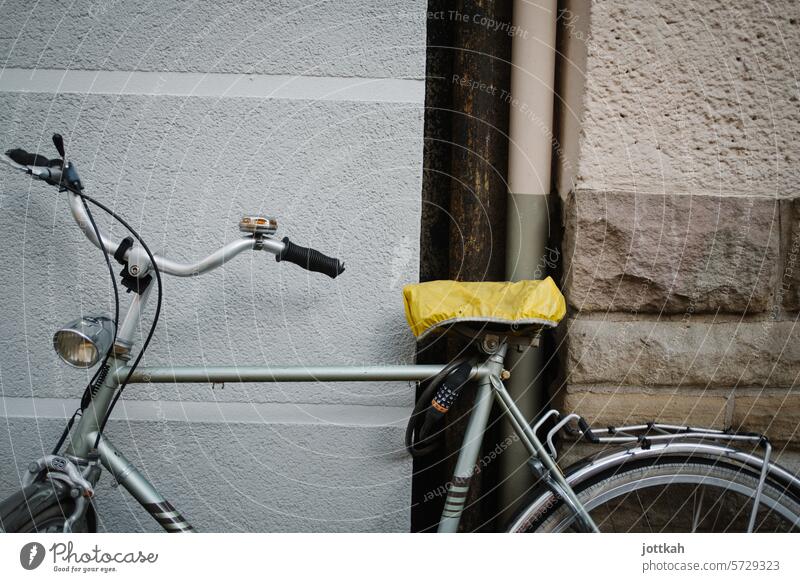 Ein altes Herrenrad mit gelbem Sattelüberzug lehnt an einer Hauswand Fahrrad Transport Rad Lenker Verkehr Verkehrswende Fahrradfahren Straße Freizeit & Hobby