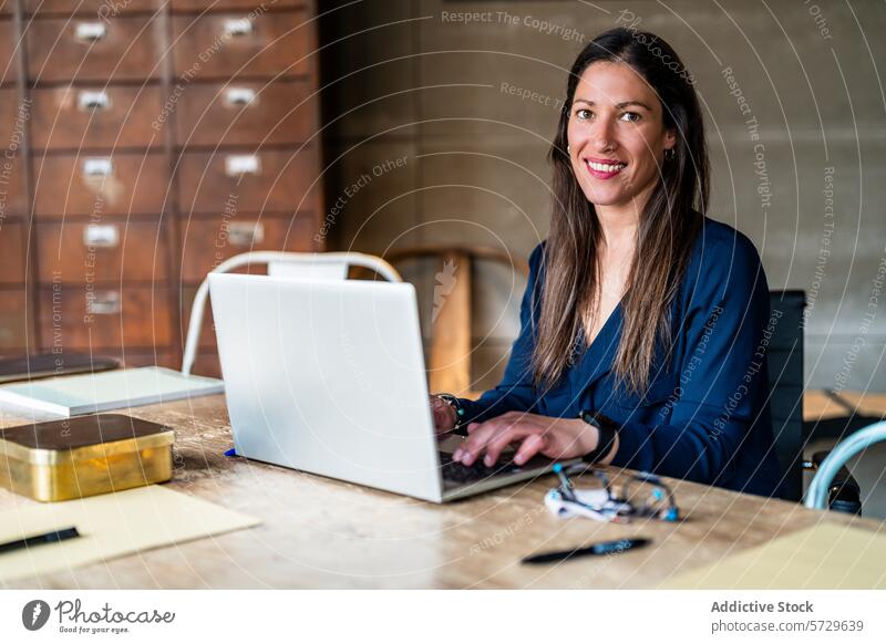 Professionelle Frau arbeitet an ihrem Laptop im Büro professionell arbeiten Unternehmer selbstbewusst in die Kamera schauen Business modern Inbetriebnahme