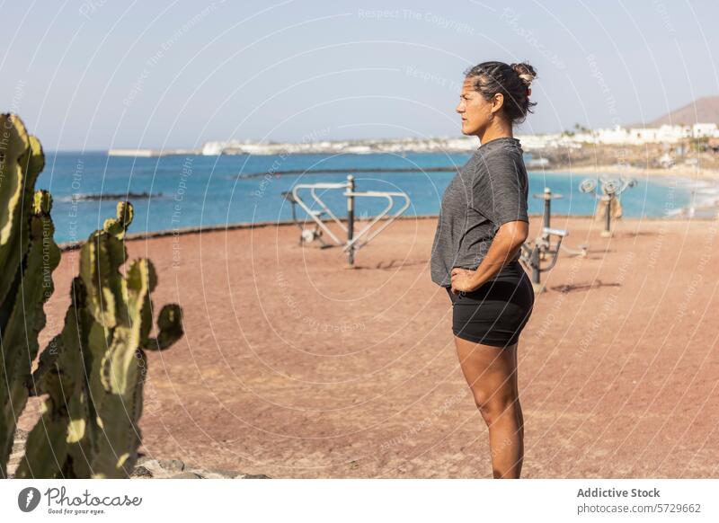 Kontemplative Frau, die in einem Fitnessstudio am Strand wegschaut im Freien MEER beschaulich Wegsehen Training Freizeit aktiv Lifestyle Küste Natur Rückansicht