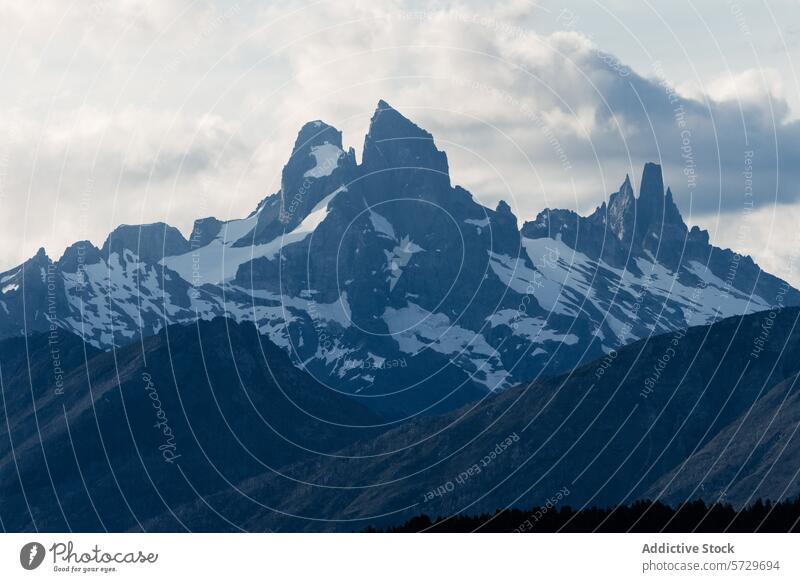 Eine atemberaubende Darstellung der zerklüfteten Berglandschaft Patagoniens im sanften Abendlicht, das die dramatischen Silhouetten und Schneeflecken zur Geltung bringt