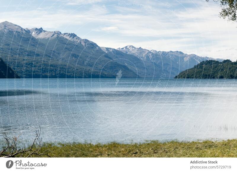 Im ruhigen Wasser eines patagonischen Sees spiegeln sich die umliegenden Bergketten und üppigen Wälder unter einem klaren blauen Himmel Berge u. Gebirge