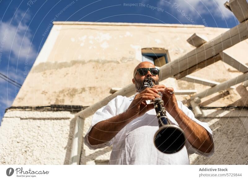 Musiker spielt Klarinette im Freien zum Internationalen Tag des Jazz Spielen internationaler Jazztag Mann männlich Leistung kahl Vollbart Sonnenbrille