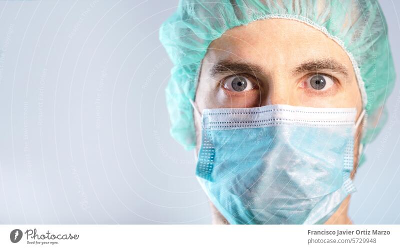 Nahaufnahme des überraschten und besorgten Gesichts des Arztes, das durch eine Maske geschützt ist. Selektiver Fokus Mann Gesichtsmaske Porträt Erwachsener