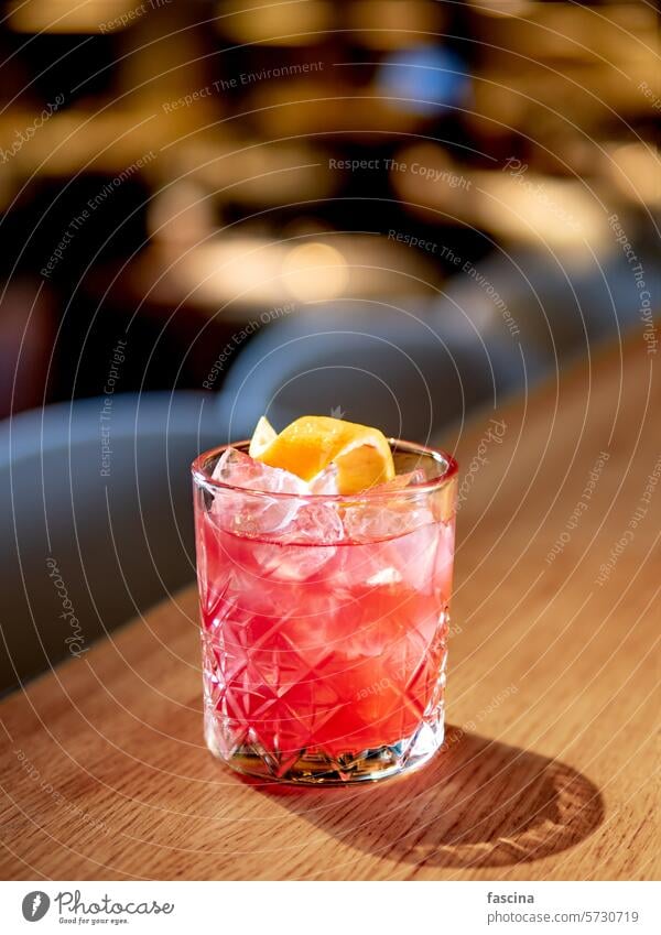Transparenter rosafarbener Alkohol-Cocktail, Wodka-Gin-Tonic Orangenschalenspirale Vodka gin-tonik durchsichtig Glas Bar Abfertigungsschalter dekoriert trinken
