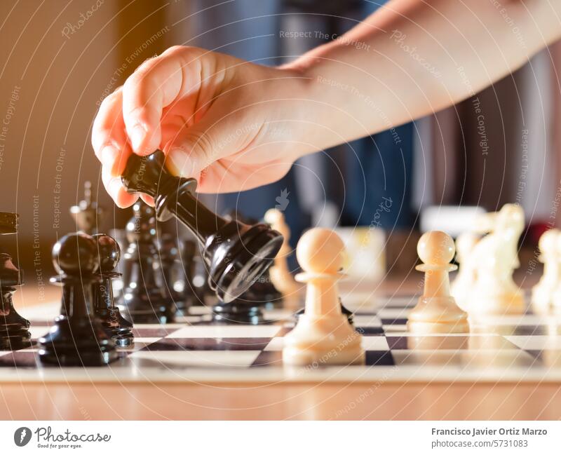 Die Hand eines Mädchens bewegt eine Schachfigur. Strategie horizontal Konflikt Schlacht Konkurrenz weiße Farbe Schwarze Farbe Krieg Kontemplation Spielen