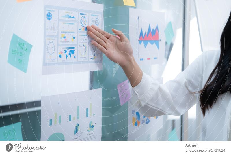 Eine Frau, die auf ein Diagramm an der Wand zeigt. Business Büro professionell korporativ arbeiten Technik & Technologie Sitzung Strategie Grafische Darstellung