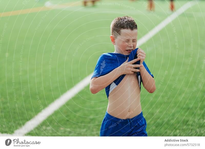 Kleiner Junge mit Unbehagen während eines Fußballspiels Verzweiflung Verletzung Erschöpfung Sport Feld sonnig Tag jung Spieler im Freien Aktivität physisch
