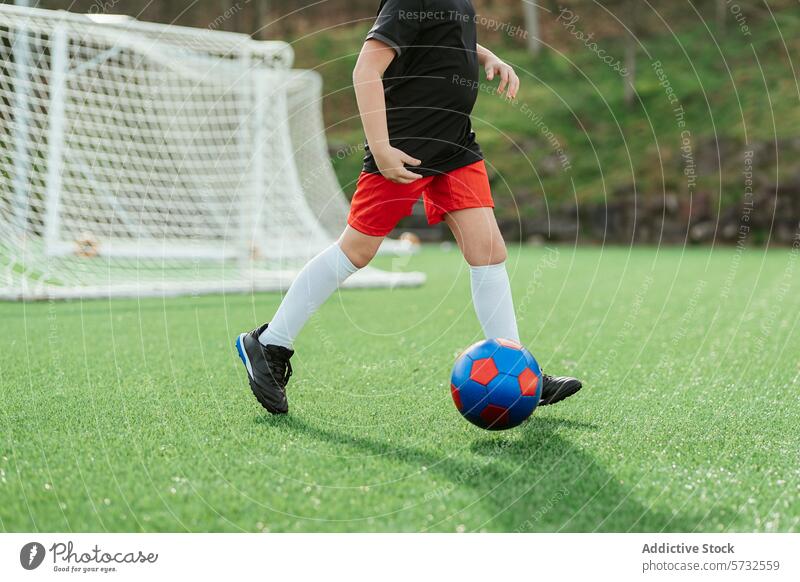 Junger Spieler in Aktion auf dem Fußballplatz Jugend dribbeln Ball grün Sport Kind spielen sportlich im Freien Übung Gesundheit Lifestyle Freizeit Aktivität