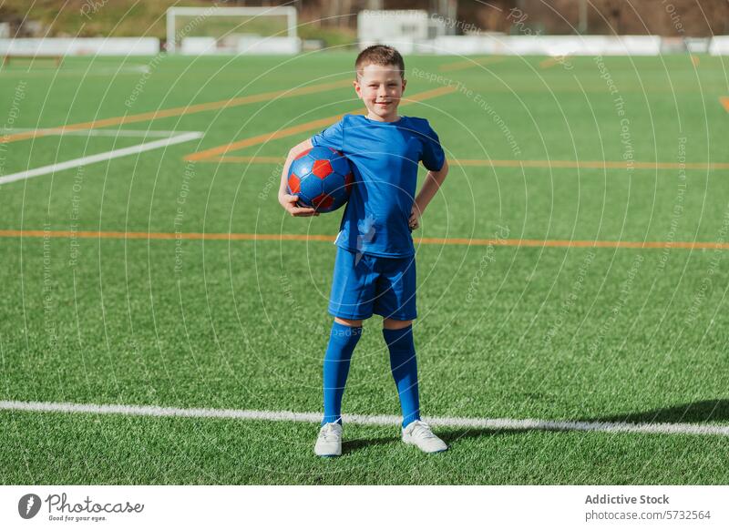 Junger Fußballspieler lächelt auf dem Spielfeld mit einem Ball Sport Feld jung Spieler Lächeln selbstbewusst Daumen hoch Ausrüstung Jugend aktiv Gesundheit
