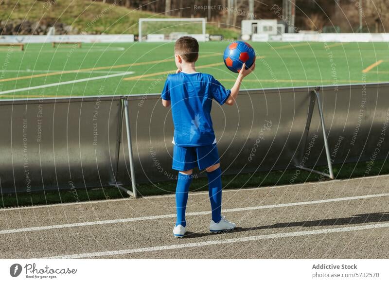 Junge Spielerin bereitet sich auf ein Fußballspiel vor Kind Seitenlinie Ball Sport jung Feld blau Uniform Beteiligung Vorfreude Streichholz Athlet im Freien