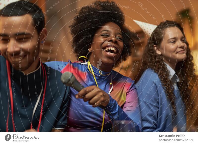 Porträt einer schwarzen jungen Frau, die mit echten Gefühlen lacht, während sie mit Freunden zu Hause eine Party feiert heimwärts Menschengruppe schwarze Frau