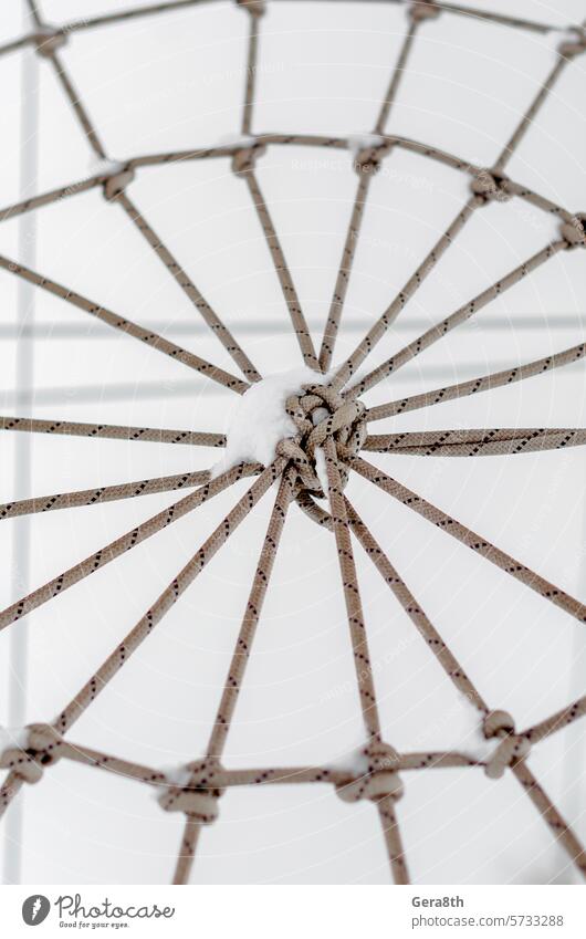 gebundenes Seil im Schnee Nahaufnahme abstrakt abstrakter Hintergrund Zugehörigkeit Anhang Zusammenhalt Rückwand Hintergrund der Seile Kabel Spinnennetz