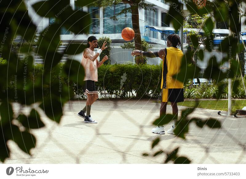 Beste Freunde spielen Streetball an einem sonnigen Nachmittag, Konzept für einen aktiven Lebensstil Spiel Freizeit Spaß Wochenende Lifestyle Zusammensein