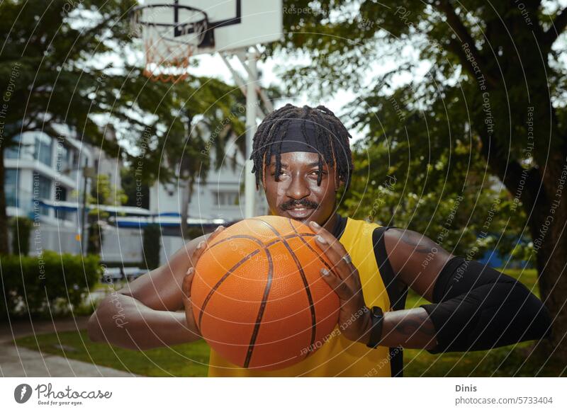 Porträt eines positiven Basketballspielers, der auf einem Straßenplatz trainiert Spieler Streetball Training werfen Ball Typ aktiv Sportler Athlet Spaß Tor