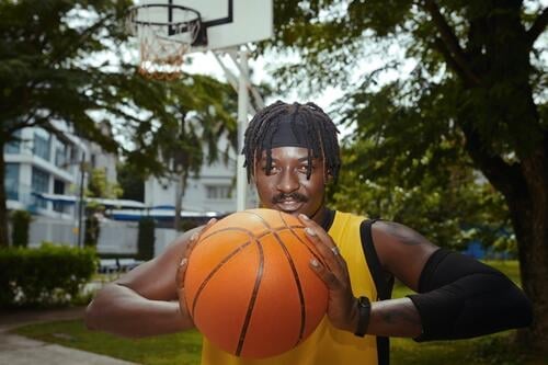 Porträt eines positiven Basketballspielers, der auf einem Straßenplatz trainiert Spieler Streetball Training werfen Ball Typ aktiv Sportler Athlet Spaß Tor