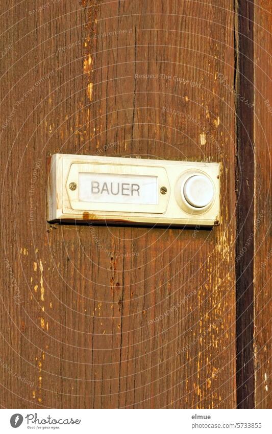 Klingelknopf mit Namensschild BAUER an einer braunen Holzwand Bauer wohnen Adresse Bauernproteste Familienname Schilder & Markierungen Orientierung Blog