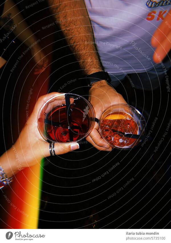zwei Personen halten Gläser mit Getränken auf einer Party Menschen Hände Brille Farben rot spritzen campari Italien Italienisch happyhour Nacht Festa