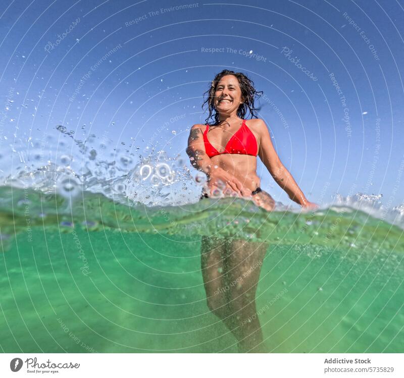 Frau genießt ein erfrischendes Bad im klaren blauen Wasser schwimmen übersichtlich Sommer untergetaucht funkelnd Sonne Strahlen Bikini rot Lächeln Glück