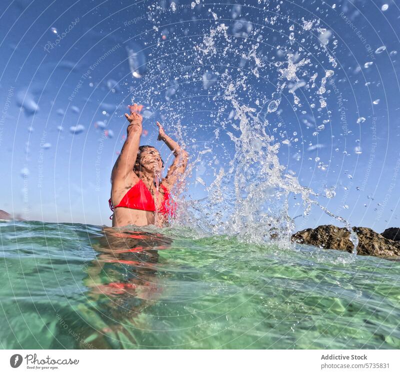Fröhliches Plätschern in kristallklarem Sommerwasser platschen Wasser schwimmen Badeanzug rot Freude übersichtlich MEER Sonnenlicht funkeln Frau Überschwänglich