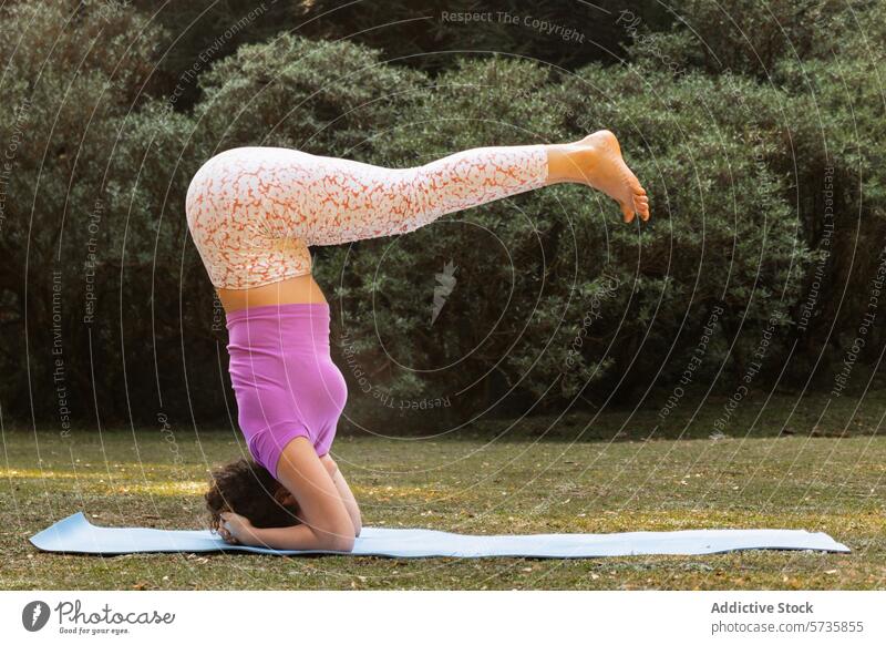 Ein engagierter Yogi zeigt einen perfekten Kopfstand auf einer Yogamatte inmitten der sanften Kulisse eines sonnenbeschienenen Parks Natur Frau Pose