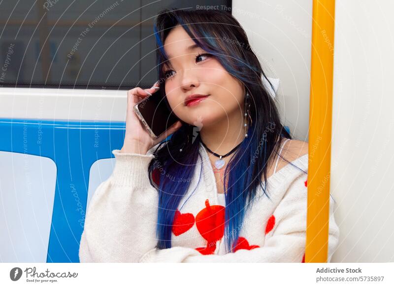Gen Z Chinese Girl Chatten am Telefon in der U-Bahn gen z Chinesisch Mädchen Smartphone blaue Haare modern Lifestyle jung Frau sprechend öffentlicher Verkehr