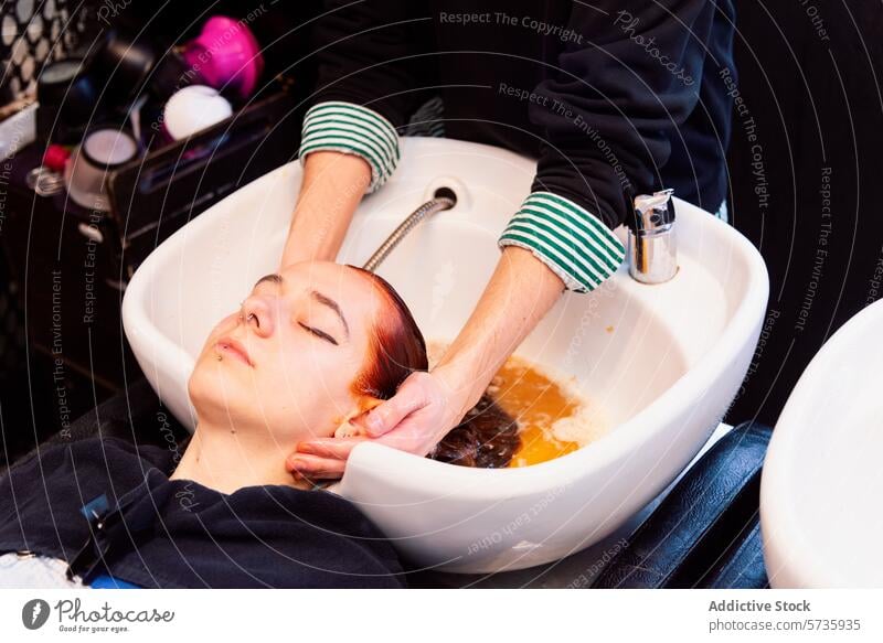 Entspannende Haarwäsche in einem professionellen Salon Friseursalon Haare waschen Klient Stylist verwöhnend Schönheit Pflege Haarwaschmittel Konditionierer