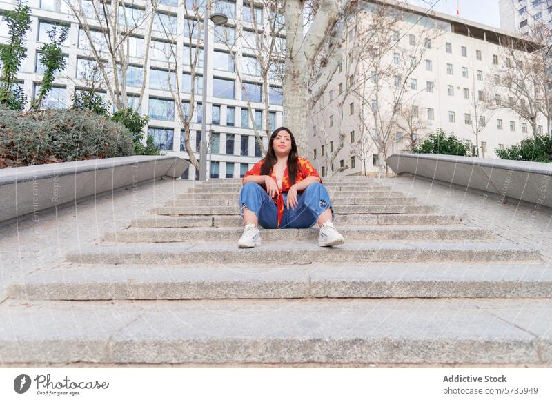 Urbane Frau auf Betonstufen sitzend Großstadt urban Sitzen Treppe Wegsehen nachdenklich entspannt lässig im Freien Straße Gebäude Architektur tagsüber Stadtbild