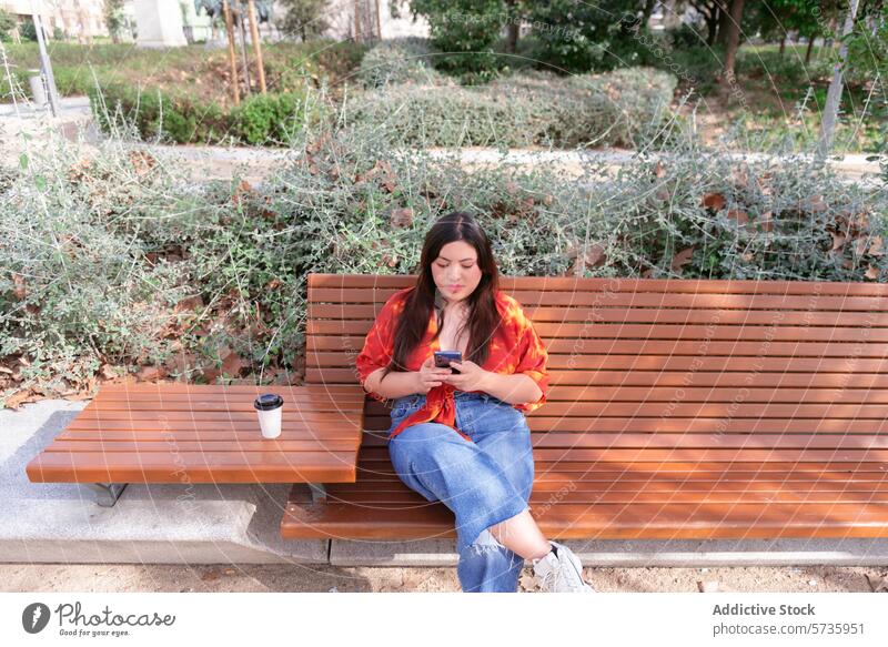 Urbane Frau entspannt mit Telefon auf Parkbank Großstadt Smartphone Kaffee lässig urban Sitzen entspannend im Freien vertieft per Telefon herabsehend