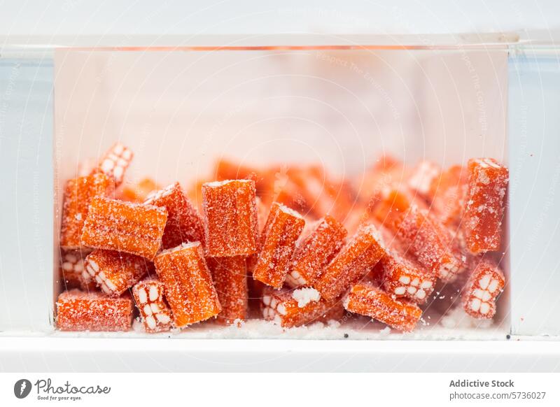 Orangefarbene Bonbonstangen im Glas mit Zuckermantel orange Stöcke Nahaufnahme aromatisiert saftig granuliert durchsichtig süß Konditorei Leckerbissen Dessert