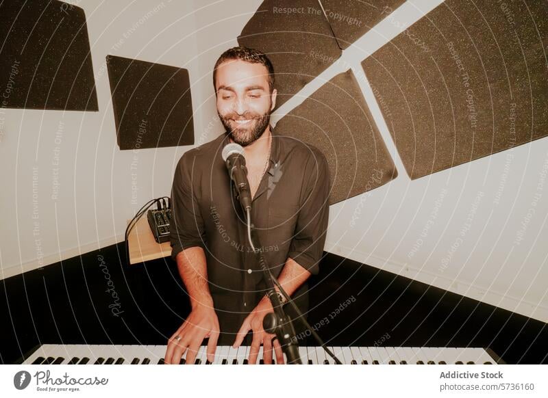 Lächelnder männlicher Musiker, der Klavier spielt und singt Mann Gesang Mikrofon Spielen freudig Keyboard Leistung Entertainment Atelier Musikinstrument