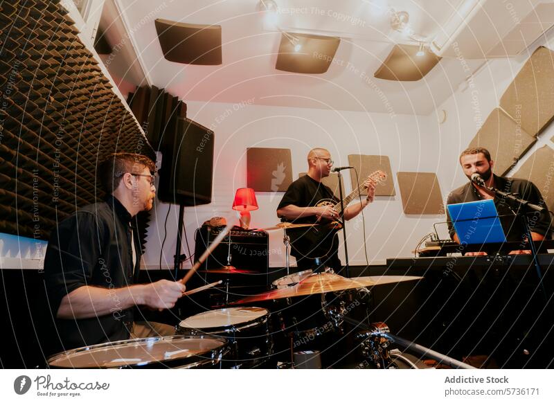 Männer, die in einem Heim-Musikstudio auftreten Band männlich Heimstudio Schlagzeuger Gitarrenspieler Sängerin Akustikplatte Leistung Sitzung Musiker Trommel