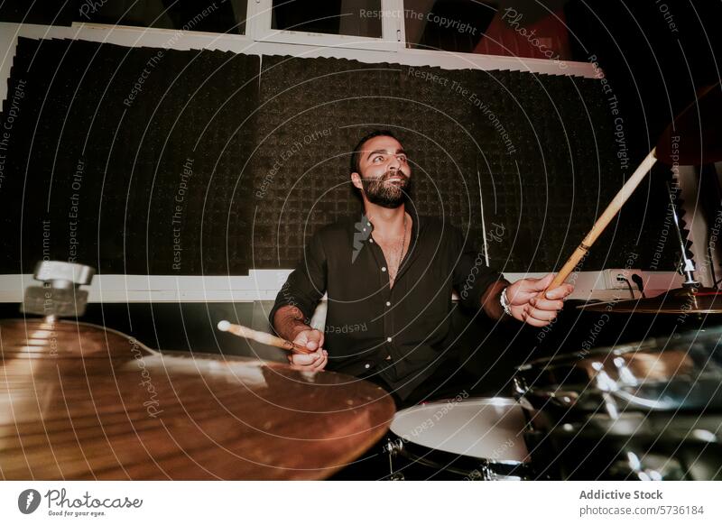 Leidenschaftlicher männlicher Schlagzeuger, der in einem dunklen Studio spielt Mann Trommeln Trommelschlegel Musik Musiker Leistung Spielen Instrument Band