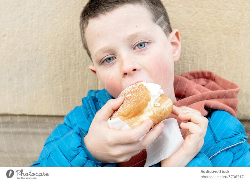 Kleiner Junge genießt ein leckeres mit Sahne gefülltes Gebäck Essen Snack süß Kind Hunger Leckerbissen Lebensmittel Dessert Genuss Geschmack Ablass Zucker