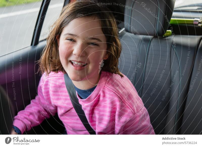 Fröhliches Mädchen in einem Auto sitzend und angeschnallt Kind PKW Sitzgurt Sicherheit Lächeln heiter Reise Verkehr reisen Fahrzeug jung Fröhlichkeit Freude